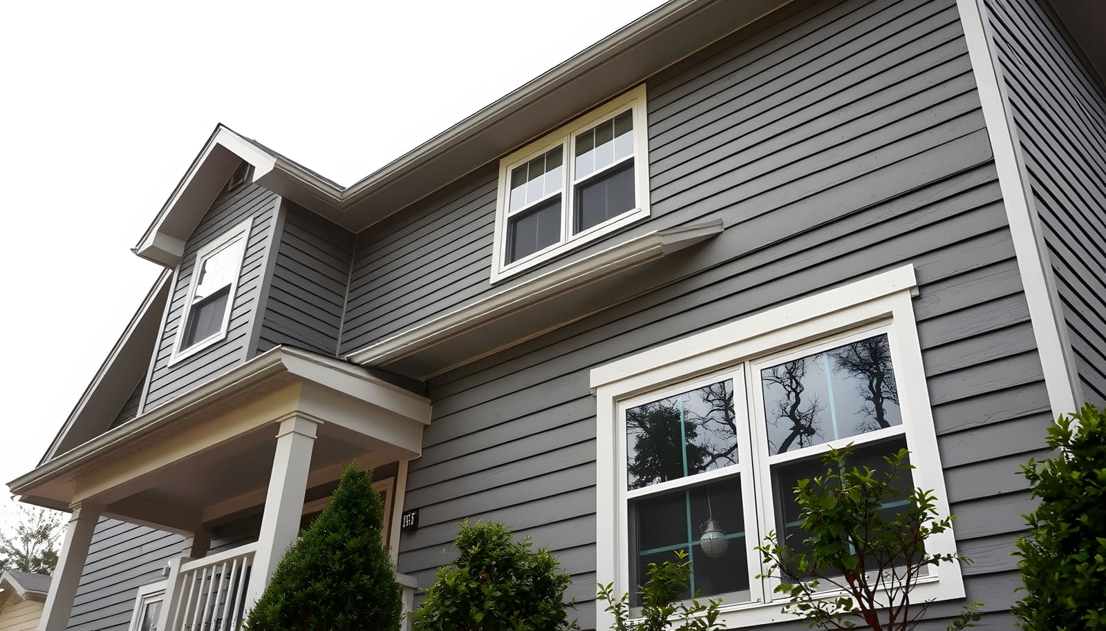 Two-story home with new gray lap siding and white-trimmed windows